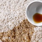 Overturned cup with spilled tea on a carpet