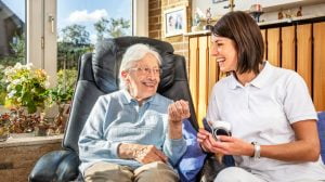 Domestic assistant and an elderly woman smiling