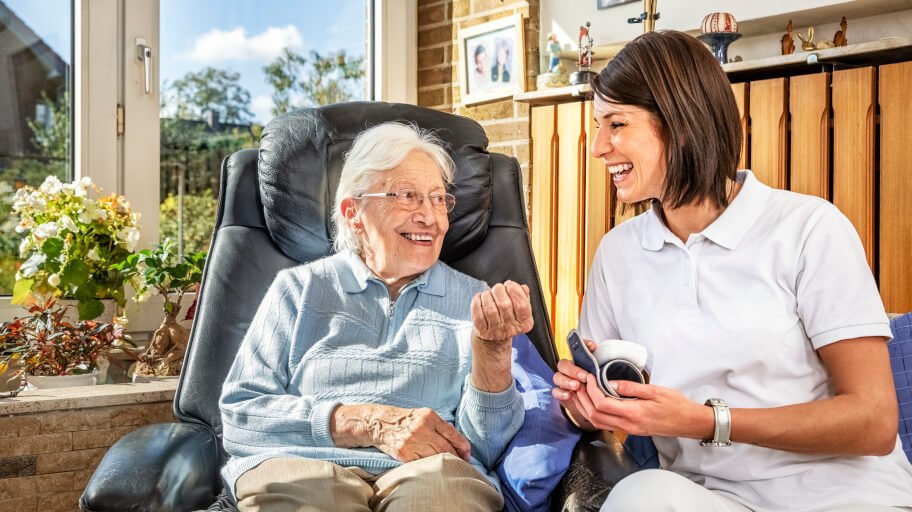 Domestic assistant and an elderly woman smiling
