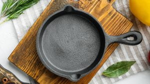 Photo of a clean cast iron pan on a wooden board.