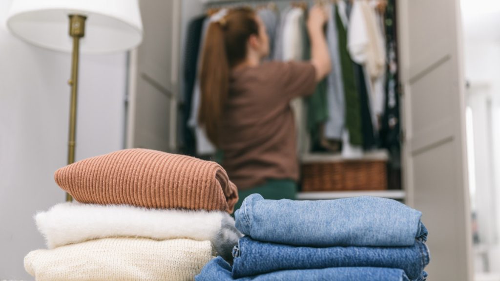 Woman decluttering clothes from a wardrobe