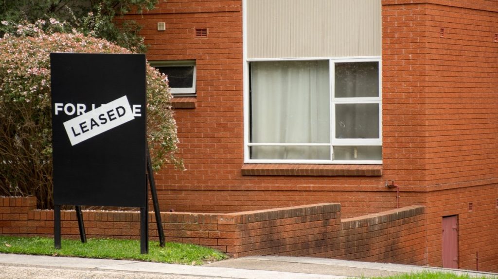 For lease and leased sign on a black display outside of residential apartment building