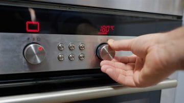 Hand setting temperature on pyrolytic oven.