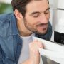 A man smelling his nicely cleaner free of commercial oven cleaning chemicals oven.